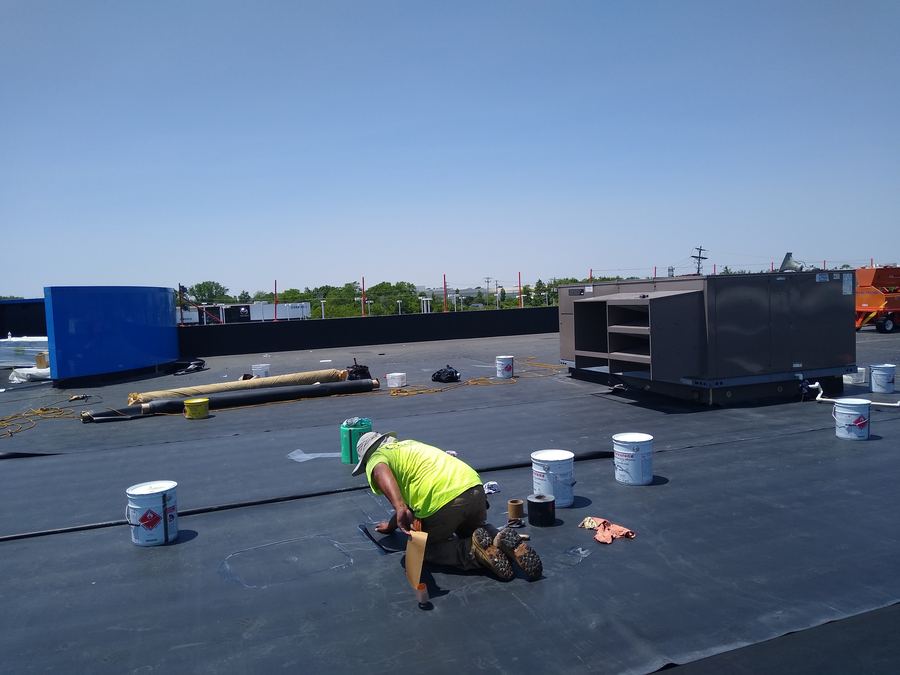 Crew seaming an EPDM rubber roof membrane